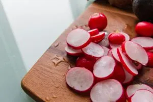 red radishes sliced on a chopping board